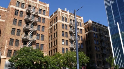 Fire escape ladder outside residential brick building in San Diego city, USA. Typical New York style emergency exit for safe evacuation. Classic retro house exterior as symbol of real estate property