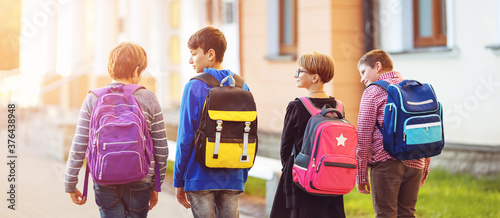 Cuadros en Lienzo Children with rucksacks standing in the park near school