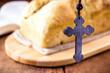 homemade bread made in the Easter and Eucharist period, called Christ bread, religious symbol, with Bible and crucifix in the background