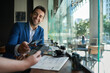 © mavoimages - Smiling man paying his cafe waiter using nfc technology