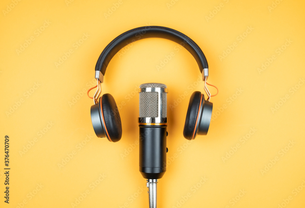 podcasting concept, directly above view of headphones and recording microphone on orange background - obrazy, fototapety, plakaty 
