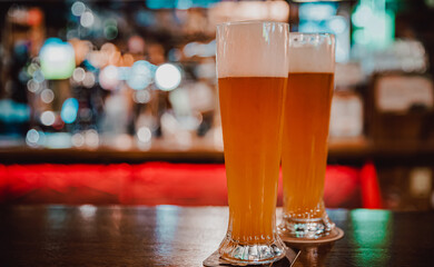 wo glass of light beer stands on a table in a bar or pub