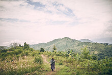 Woman Walks On Dirt Path In Uganda