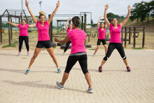 Group Of Woman Performing Jumping Jacks Exercise At Boot Camp