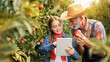 Portrait of bearded grandpa farmer and little granddaughter with digital tablet