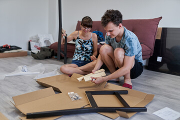 Young couple assembling their furniture