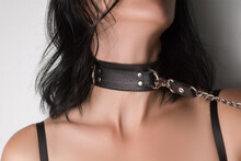 The Young Woman Is Wearing A Black Leather Collar. Conceptual BDSM Photo.