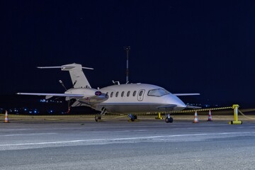 Wall Mural - Front side view of white business airplane with twin turboprop engines mounted in pusher configuration. Night dark blue sky. Modern technology in fast transportation, business travel and tourism.