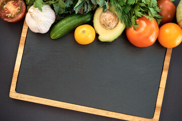 Vegetables dark background with copy space. Healthy meal. Menu, price background. Vegetables on black chalkboard.