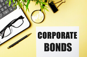 CORPORATE BONDS written on a light yellow background near a computer, magnifier, glasses and a pen. Business concept