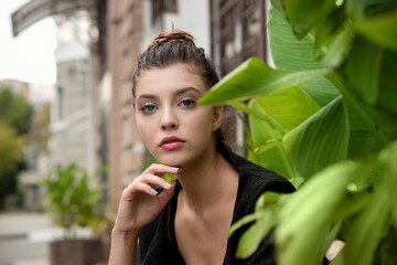 Portrait of young pretty student woman sitting at the city openspace.