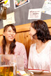 © Paylessimages - 居酒屋で会話する女性