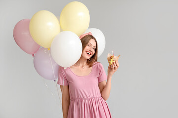 Sticker - Young woman with balloons and birthday cake on grey background