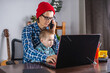 © Artem - Modern man is working on a laptop, and his little son is sitting on his lap. Concept of family and remote work from home
