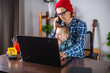 © Artem - Modern man is working on a laptop, and his little son is sitting on his lap. Concept of family and remote work from home