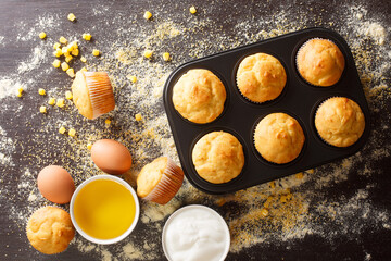 Canvas Print - Healthy corn muffins in a baking dish and ingredients close-up on the table. horizontal top view from above