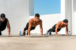© Atstock Productions - Group of fit sports men doing bodyweight push up exercise outdoors on building rooftop