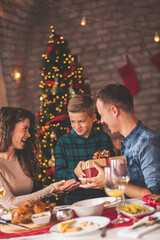 Mother and father giving Christmas present to their son