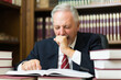 © Minerva Studio - Sleepy business man lawyer yawning. Surrounded by many books