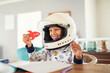 © Rido - Child playing with astronaut helmet and rocket