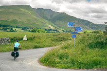 Lone Cyclist Riding The Coast To Coast (C2C) Cycle Route Through The Hills Of The Lake District, Cumbria, UK