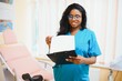 © Serhii - Professional female doctor on blurred consulting room background. African American gynecologist. Gynecology concept.