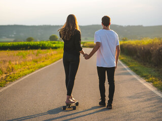 A young Caucasian couple learning to skate in the street, A shallow focus shot of a beautiful lovely couple having fun together