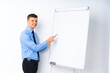 © luismolinero - Young businessman giving a presentation on white board giving a presentation on white board