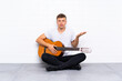 © luismolinero - Young handsome man with guitar with shocked facial expression