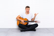 © luismolinero - Young handsome man with guitar surprised and pointing side
