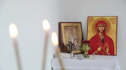 Wall Mural - Candles in front of icons in the Orthodox church. A burning candle, cross and icons in monastery. Religion. Altar in church decorated for Christmas. 
