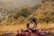 © eduard - Young girl working at a laptop at sunset  on the top of the hill. Perks of a freelance job concept.