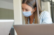 Young woman with face mask working in office