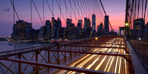 Wall Mural - Brooklyn Bridge with light trails and view on Lower Manhattan skyscrapers at Dusk. Evening in New York City, NY, USA