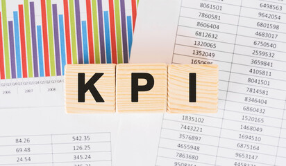 Poster - kpi word written on wood block. faqs text on table, concept.