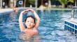 © MIA Studio - Little girl dancing under the water in the pool.Little ballerinas in ballet outdoor class.Cute little asian girl in swimming pool during a ballet dance class at hotel.