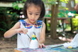 © bunyarit - Cute little girl is learning outside the classroom happily with beautiful nature And a bright smile