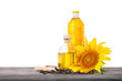 Bottles of sunflower oil with seeds and sunflower on wooden table isolated on white background