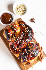 Poster - Babka or brioche bread with apricot jam and nuts. Homemade pastry for breakfast. Concrete background. Top view.