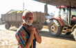 Senior farmer in front of tractor on cattle farm