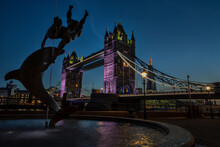 Tower Bridge With Girl With A Dolphin Fountain In Foreground At Dusk