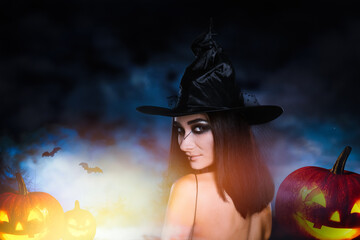 Wall Mural - Young girl dressed as witch and spooky pumpkin heads at night. Halloween fantasy