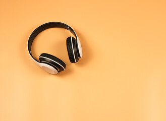  white headphones on orange  background with copy space.Music concept.