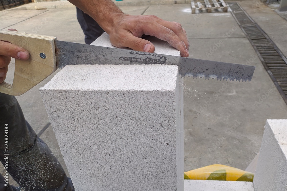 Mason Using Blocks Mason working with construction blocks made from aerated concrete. Man ...