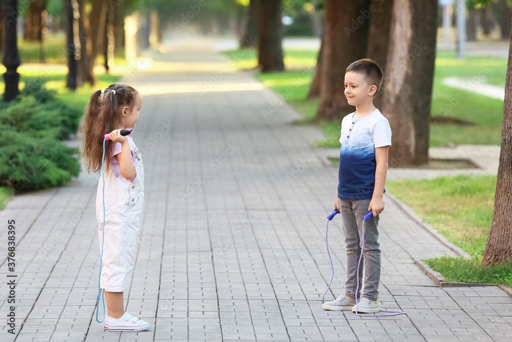 Cute little children jumping rope outdoors