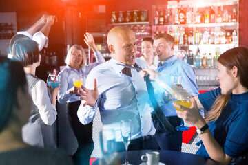 Drunken man in business suit having fun at corporate party