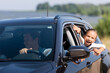 © LIGHTFIELD STUDIOS - Selective focus of excited girl looking through window of car near father