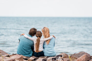 Wall Mural - Back view of daughter embracing parents on seaside