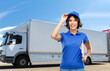 © Syda Productions - shipping, freight transportation and shipment concept - happy smiling delivery girl or warehouse worker in blue uniform with clipboard and pen writing over truck on background
