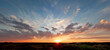 Panoramic view, beautiful sunset over the dunes, heavy clouds and sunset with sun rays, blue orange sky, sun in the middle, texel, Island
